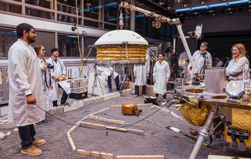 Une partie de l'équipe du système de déploiement d'InSight du Jet Propulsion Laboratory (JPL), lors d'un test de dépose du WTS au cours du sol 18. Plusieurs membres de la mission assistent à cette répétition grandeur nature depuis la galerie qui surplombe le banc de test (© NASA/JPL-Caltech/IPGP/Philippe Labrot).