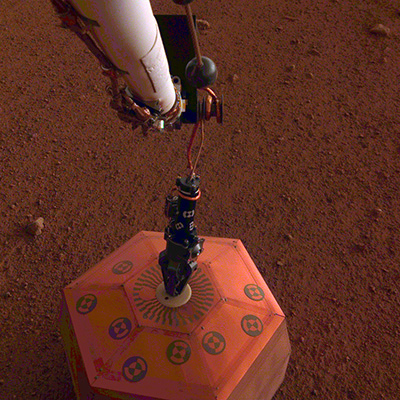 InSight’s SEIS seismometer as seen by the IDA’s instrument deployment camera (IDC) after its deployment on sol 22 (© NASA/JPL).