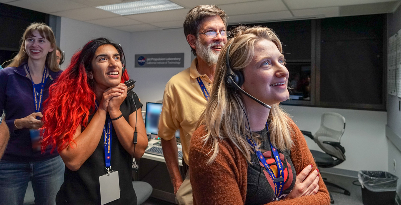 Joy on the faces of JPL engineers upon receiving the first pictures that confirmed the SEIS seismometer’s deployment on the Martian soil (19 December at 20:50 in California). In the foreground, from left to right: Farah Alibay, Ken Hurst and Jamie Singer (© NASA/JPL-Caltech/IPGP/Philippe Labrot).